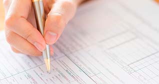 Mão segurando uma caneta fazendo prova